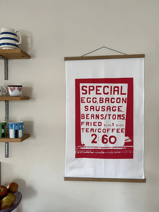Mr.PS Big Breakfast menu tea towel displayed in optional oak hanger