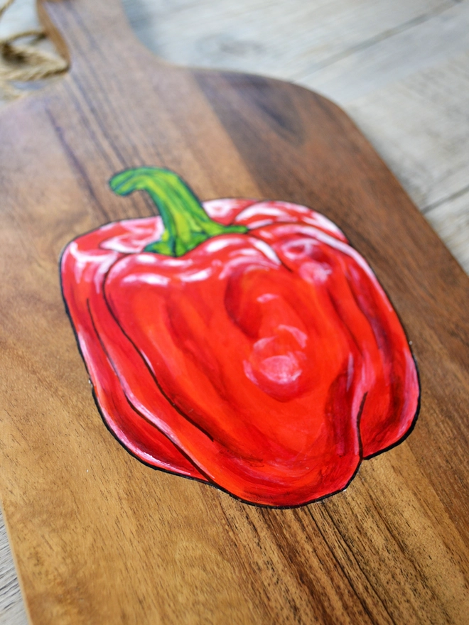 Wooden serving board with handpainted red pepper design