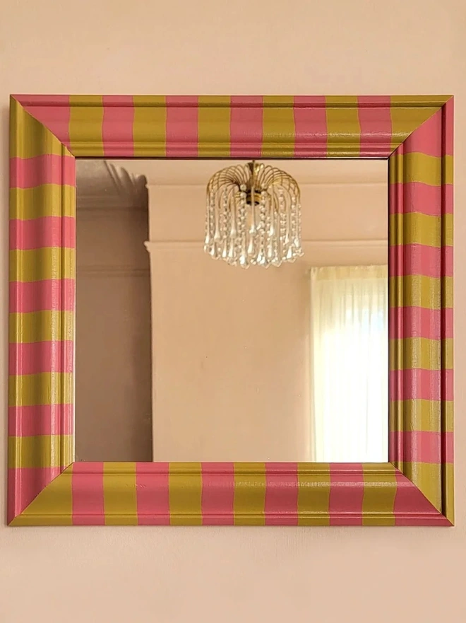wall mirror with bevelled wooden frame, painted in pink and yellow stripes