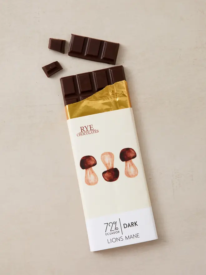 lions mane dark chocolate. a bar of chocolate in wrapping featuring illustrate mushrooms.