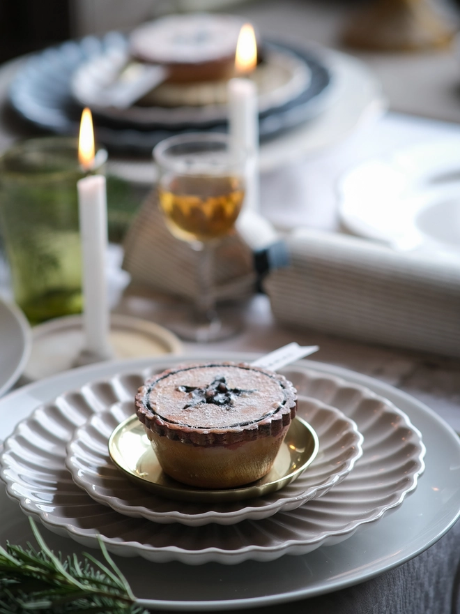 A festive handpainted wooden mince pie place setting with handwriten note to welcome your guests at the Christmas table