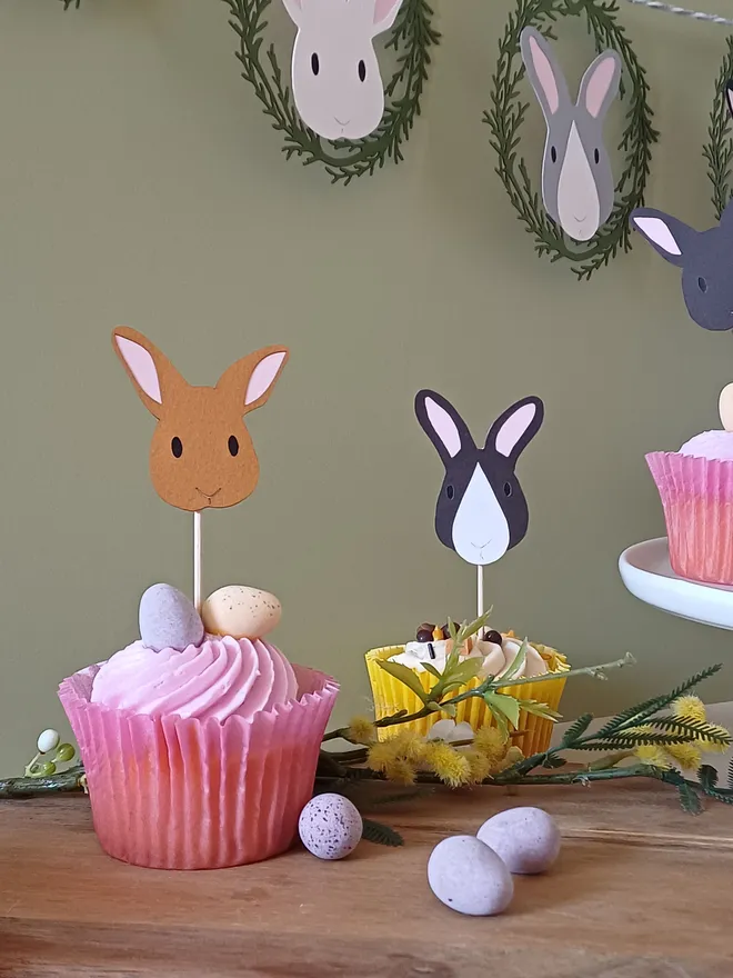 Toffee Brown and Black and White Easter Bunny Cupcake Toppers placed in pink and yellow iced cupcakes