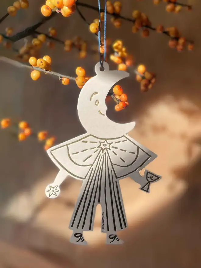 moon Christmas decoration hanging from branch