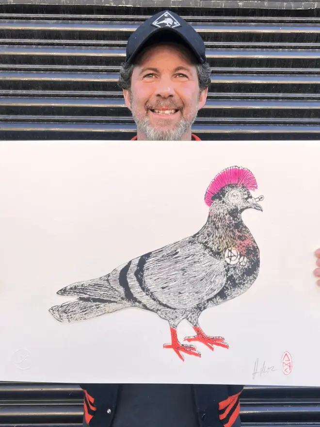 Punk pigeon lino print, with symbols, coloured with blue and pink paint with on a white background. 