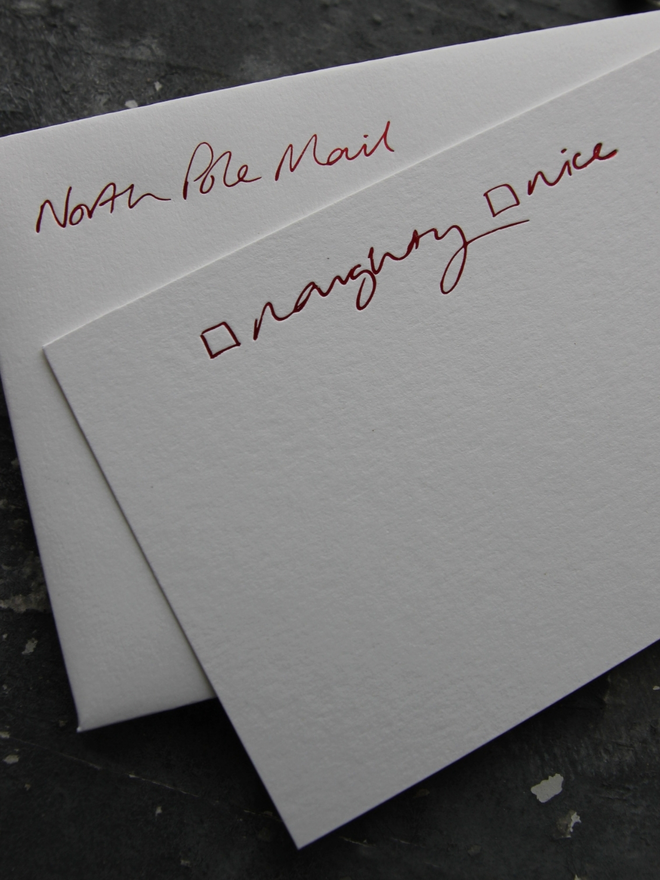 Christmas notecard from Santa that has a tick box for Naughty or Nice in red foil with an envelope that says North Pole Mail