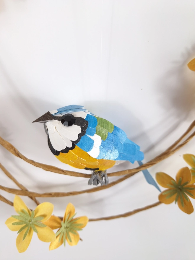 floral wreath wall art, featuring a paper sculpture of a blue tit bird