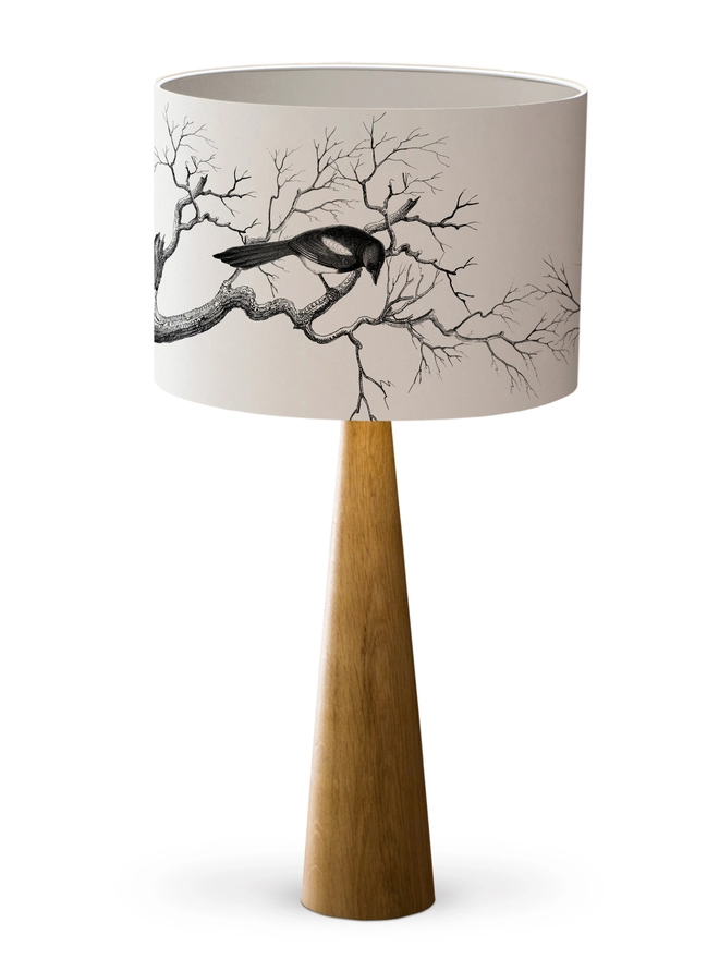 Drum Lampshade featuring magpies sitting on branches with a white inner on a wooden base on a white background