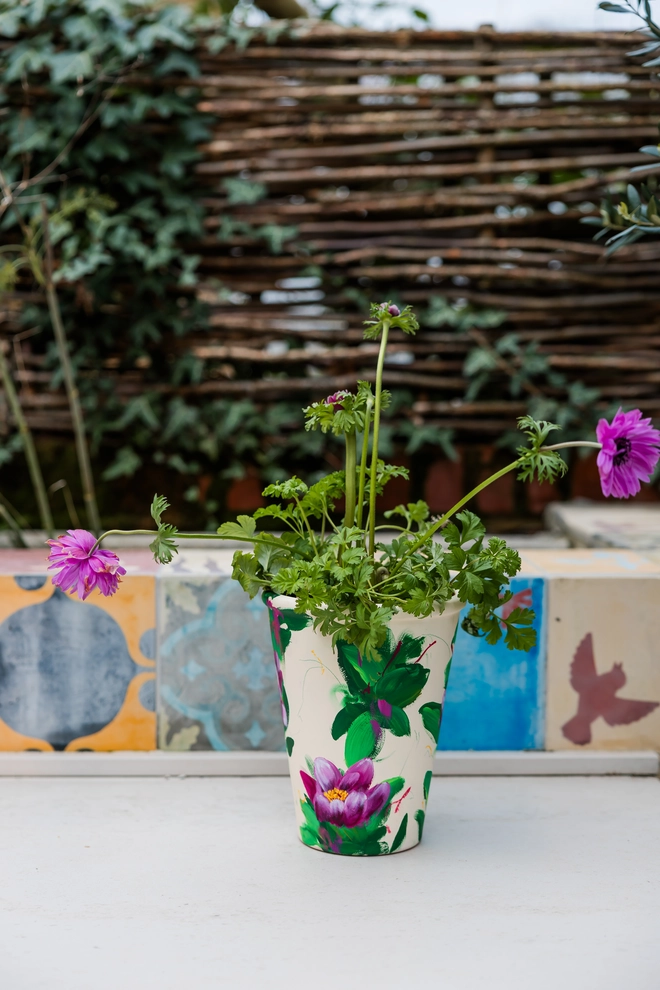 Unique hand-painted terracotta pot featuring pink peony on a cream background