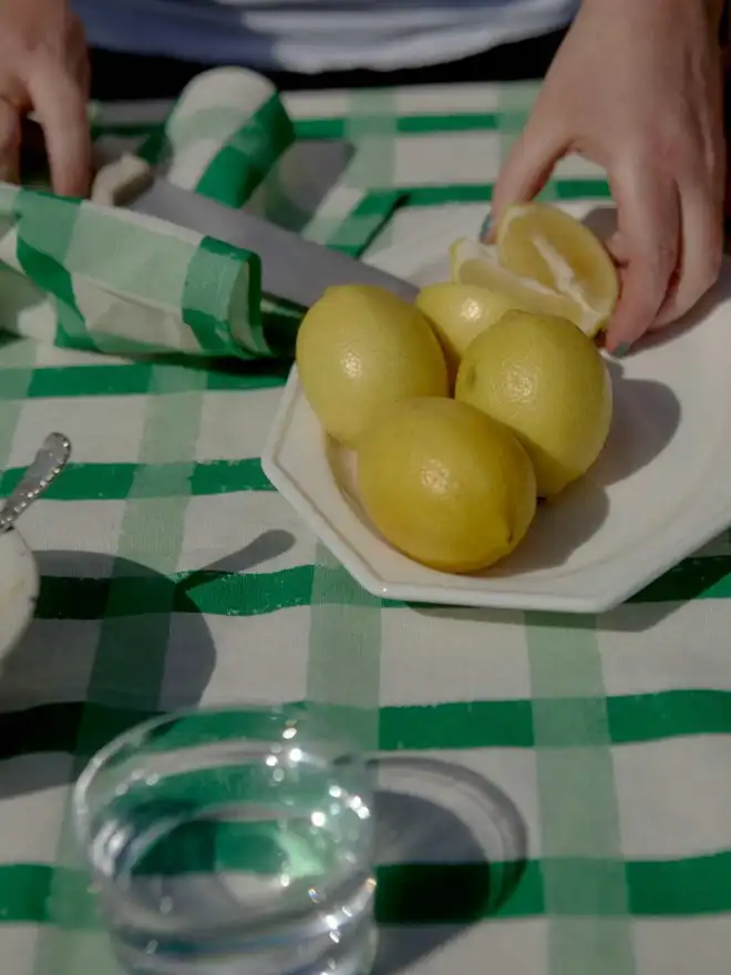 Green Gingham Tablecloth with hands cutting lemons