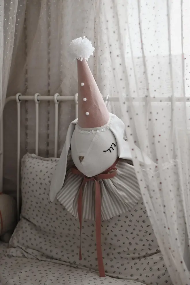 Rabbit Head Wall Mount, a cotton rabbit head wall decoration in a child's bedroom accompanied by other bedroom accessories. 