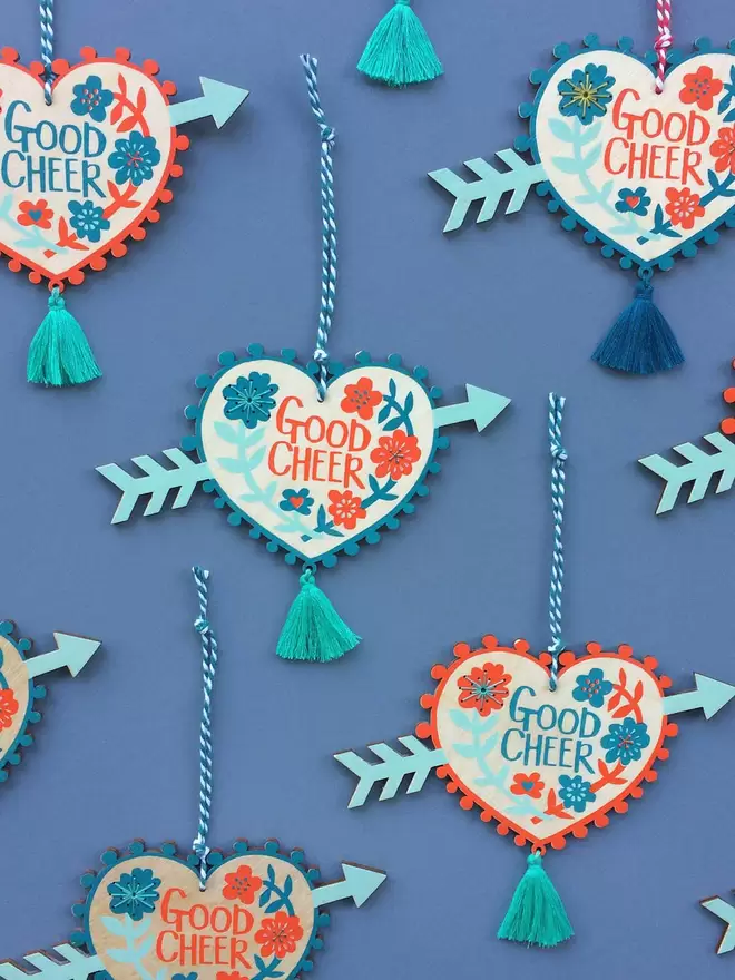 A collection of 'good cheer' charms spread out, showing the colours and hand stitched detail