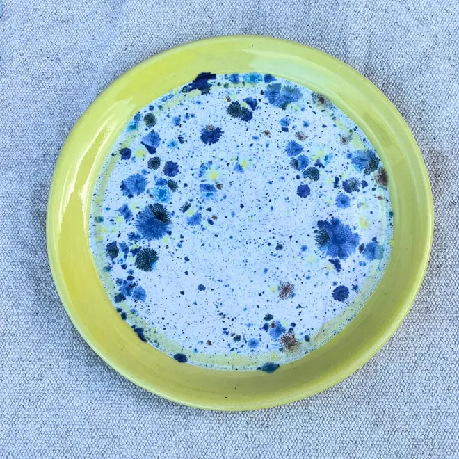 Shoreline Side Plate, a colourful plate placed on a stone surface.  