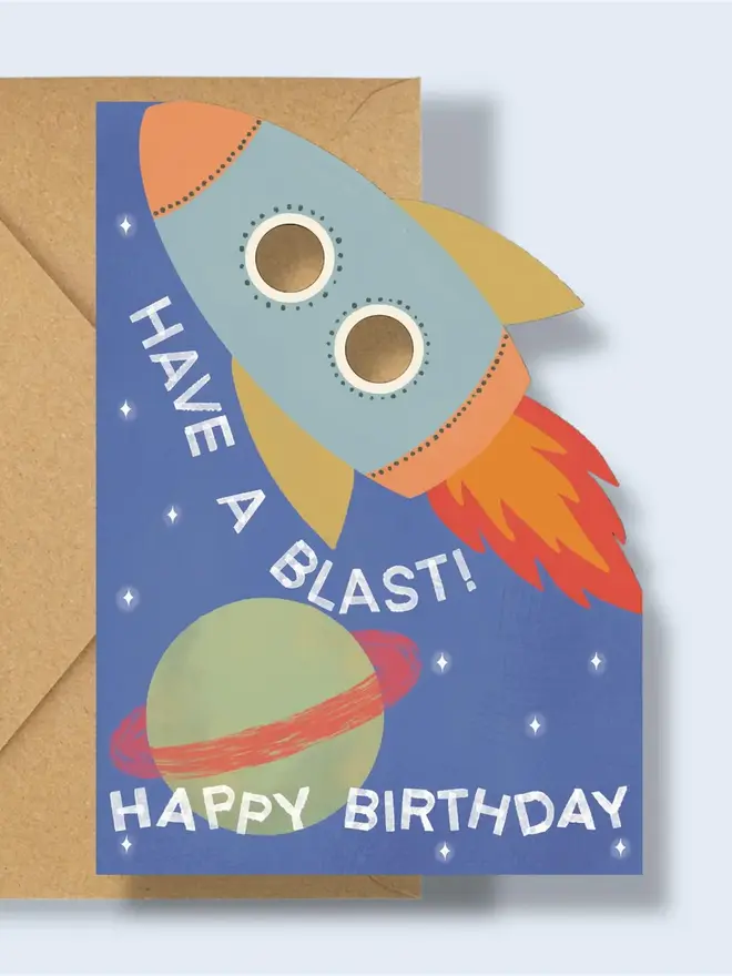have a blast rocket birthday card. blue card with illustrated rocket and planets.