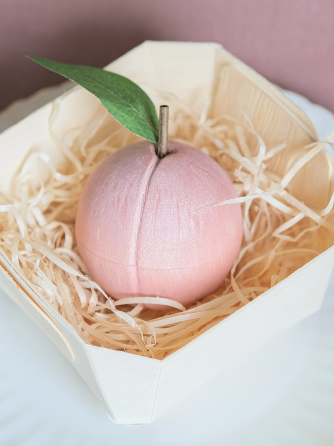 Wooden peach in a bamboo punnet