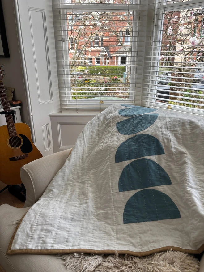 Wax & Wane Reversible Linen Throw Quilt. A blue and white geometric quilt.