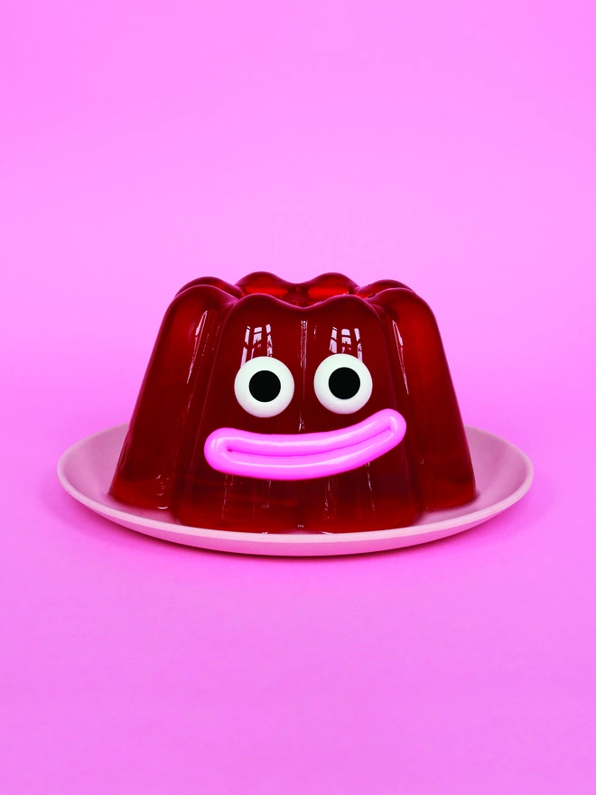 A happy red jelly on a pink plate, on a pink background 