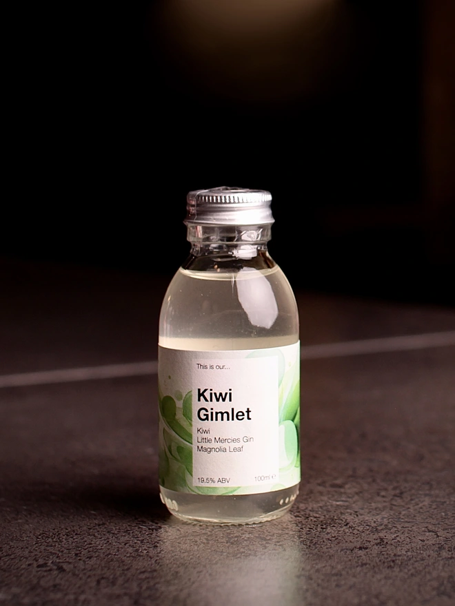 Mini bottle of Kiwi Gimlet shot against a dark background