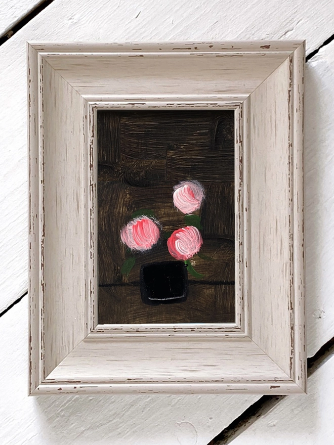 framed painting of pink flowers on dark background