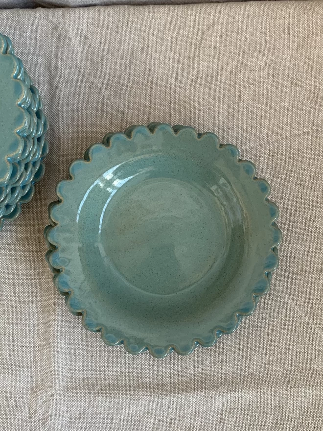 teal shallow bowl on a natural linen cloth