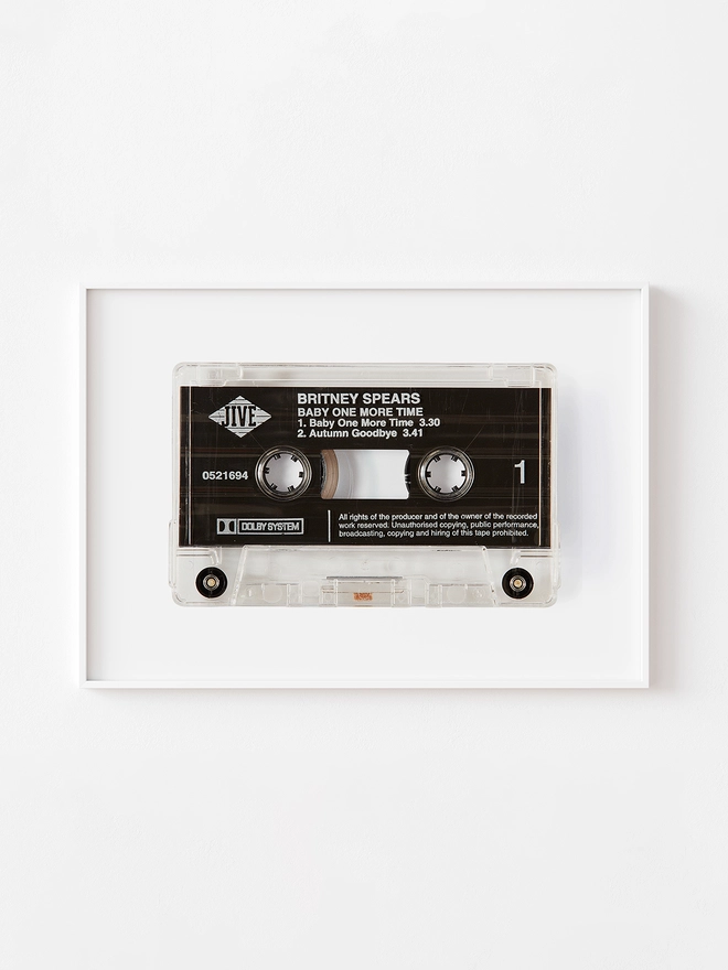 baby one more time britney spears cassette print. print framed and hung on white wall.