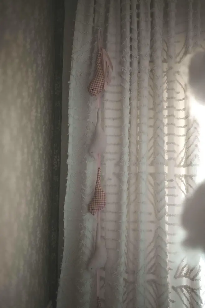 Cotton Bird Garland Decoration, a suspended red and white cotton bird garland hanging in a child's bedroom. 