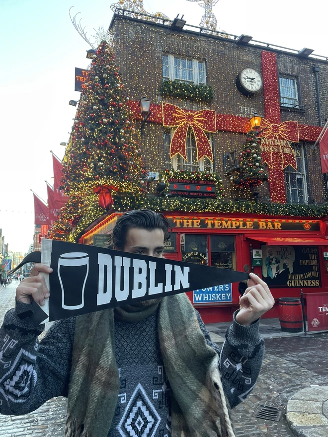 a felt pennant flag black and white, it has the word DUBLIN written in the varsity style and a pint of Guiness next to it