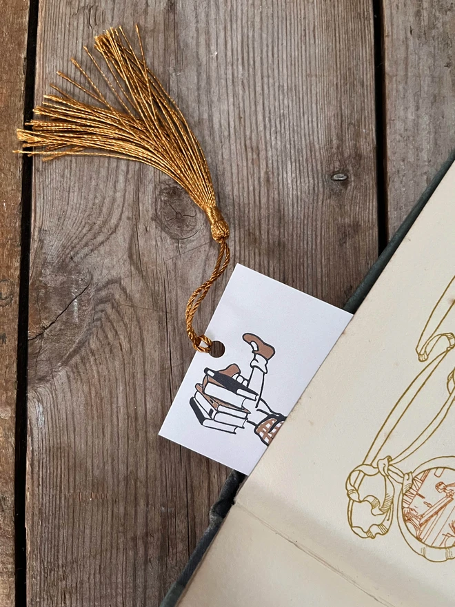 A photograph of the end of a traditional bookmark peeking out of a vintage book