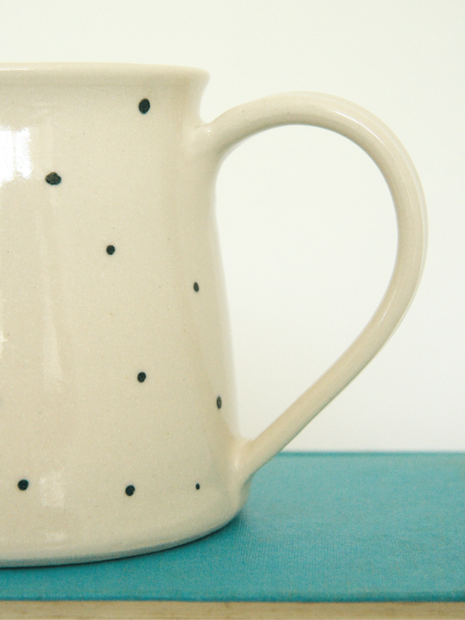 large personalised hand-thrown ceramic mug. mug photographed close up, showing the handle and the side.
