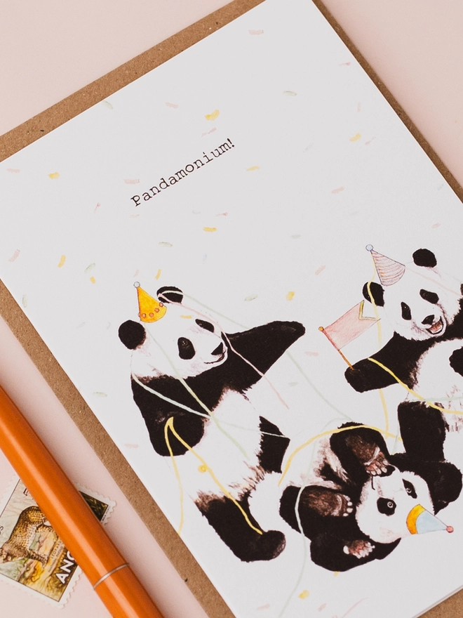 Close up of panda party birthday card with pen, postage stamp and manilla envelope