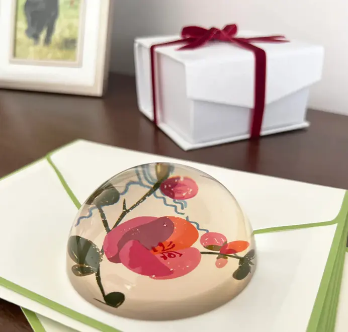 Decoupage Coco Paperweight. Round paperweight on a wooden table. 