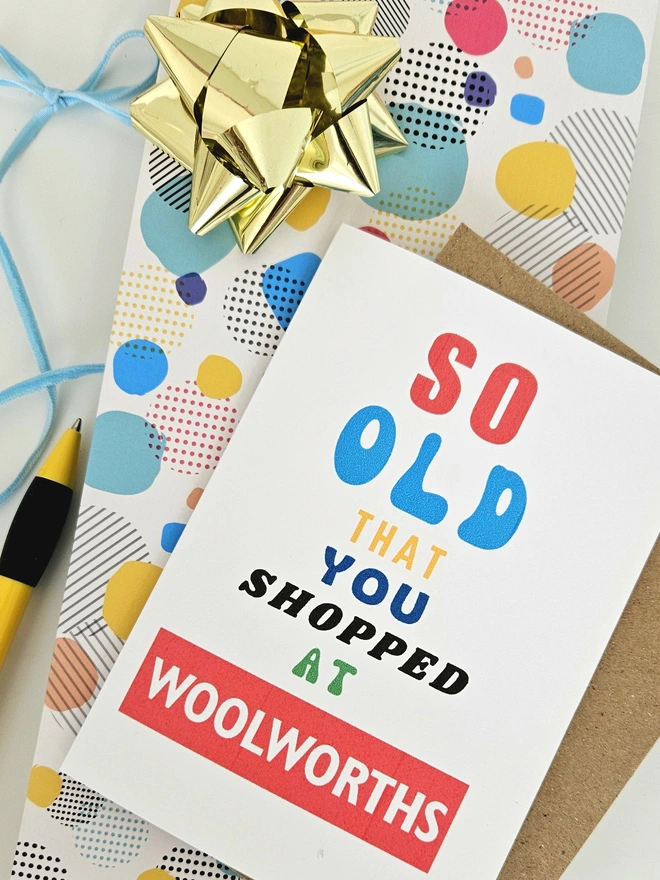 A photograph of the front of a humorous A6 greeting card illustrated using brightly coloured text and the retro shop logo. The text says so old you shopped at Woolworths.
