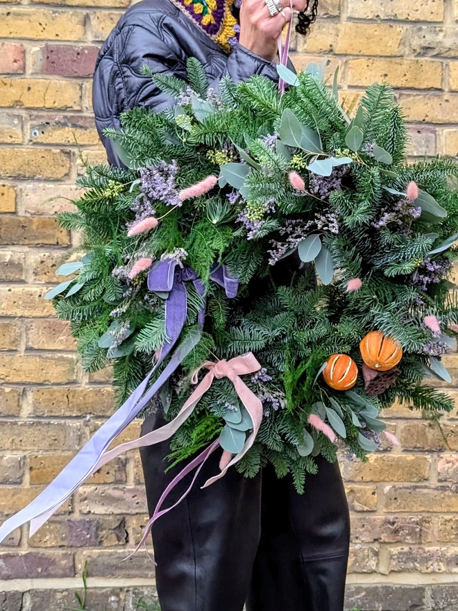 founder holding Handcrafted seasonal fresh wreath made to order, natural textures, soft greenery and delicate floral, velvet ribbon, handmade wreath, gift wreath, Christmas wreath