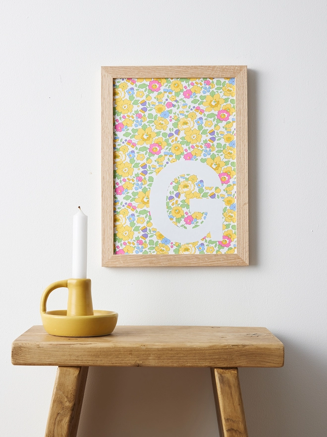 Personalised framed white initial on Liberty Betsy yellow fabric