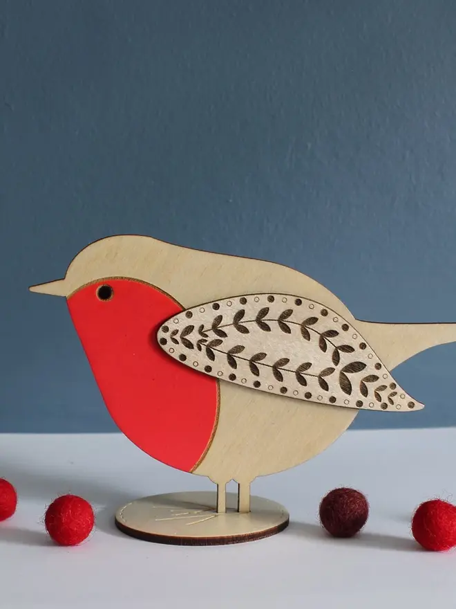 Standing Wooden Robin, red wooden bird decoration standing on a platform. 
