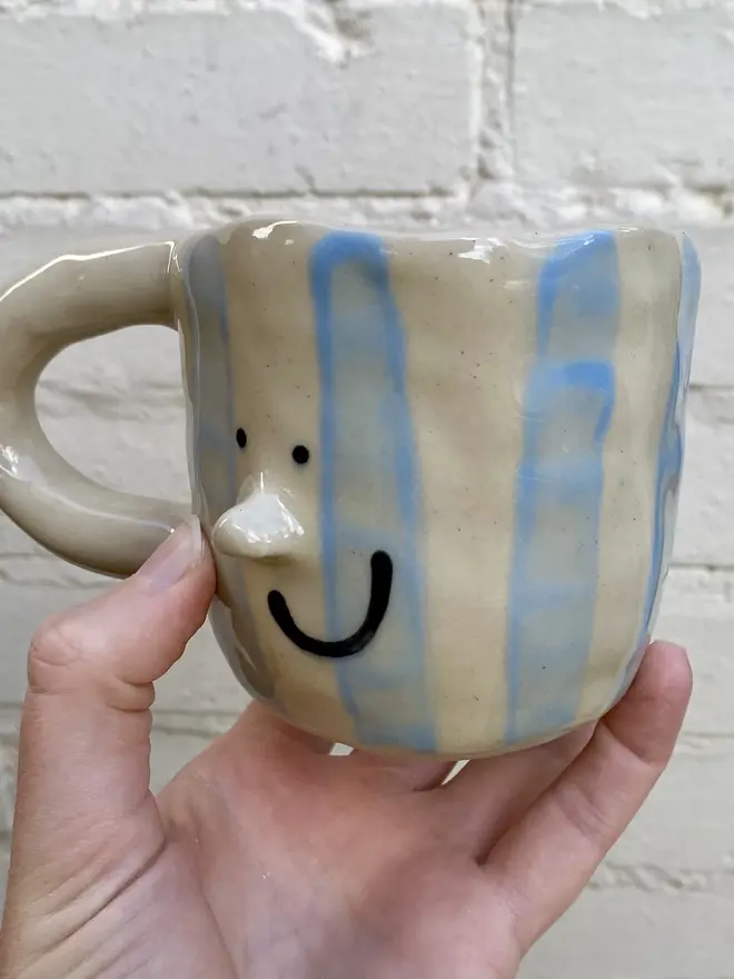 handmade ceramic smiley face blue white strip mug