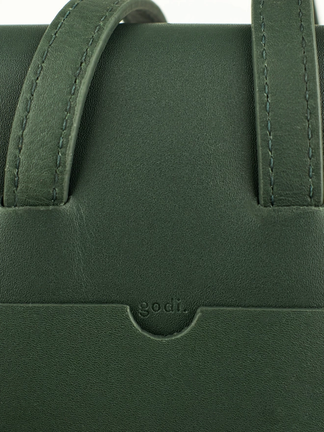 Close up of logo detail on dark green phone bag