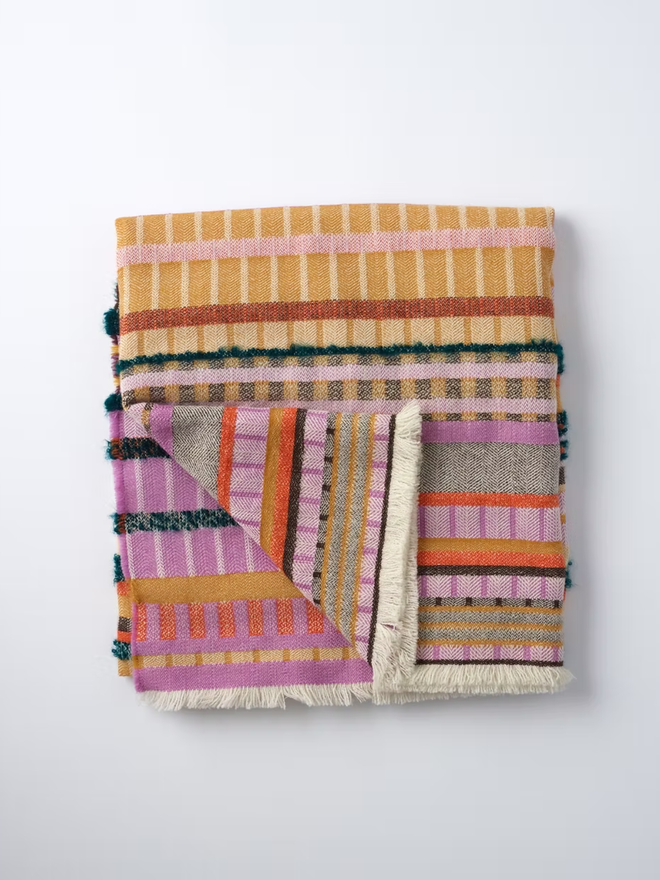 aednat lambswool blanket. a multi coloured patterned blanket photographed against a white background.