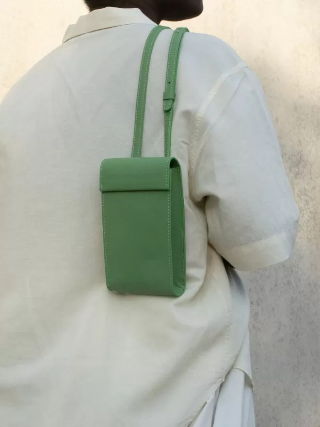 Sea Green Phone Bag worn over the shoulder on an airy cream oversized shirt. 