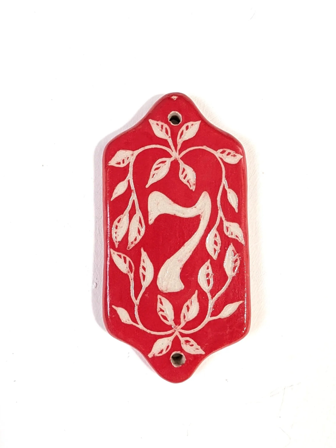 Red Sgraffito Leaf Address Tile. A tile with ‘7’.
