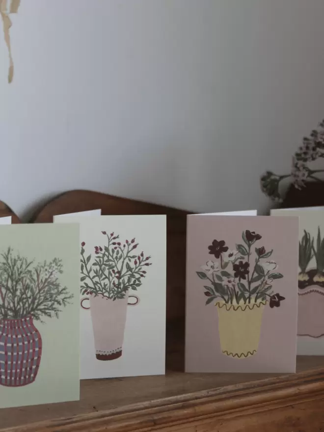 set of 4 flower cards on wooden shelf. 