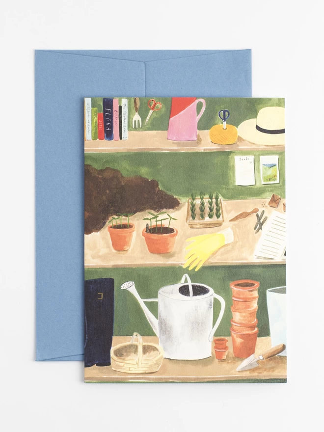A greetings card featuring an illustration of the shelves within a potting shed. There are gardening books, seeds, plants waiting to be potted up and a stack of terracotta pots. 