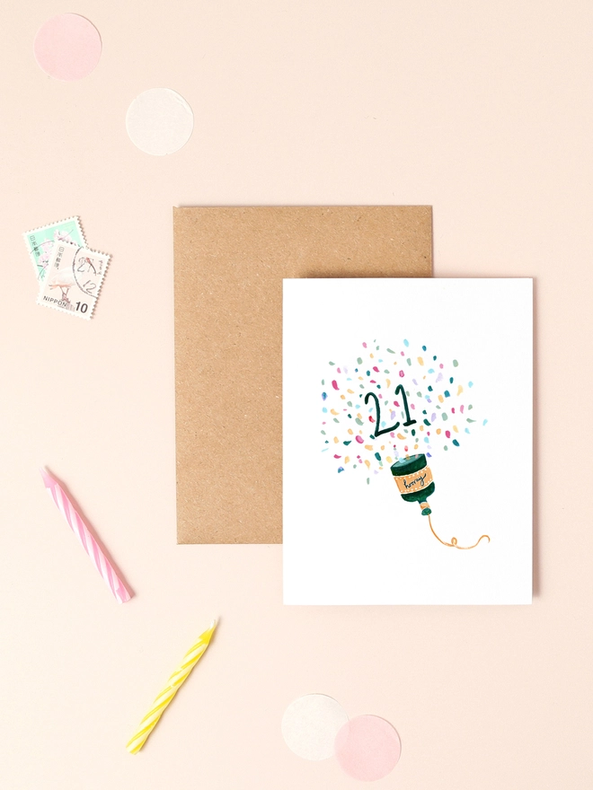 A vibrant illustration of a party popper bursting with colorful confetti, accompanied by the handwritten message "Hooray!" in a playful, cursive font. The design features bright, celebratory colors and a minimalist layout, capturing the joy and excitement of a 21st birthday.