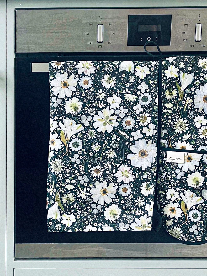 Cotton tea towel with a pressed flower design in black and white.