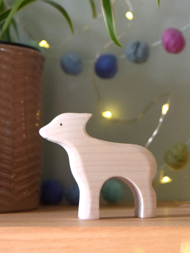 wooden toy white lamb standing on shelf