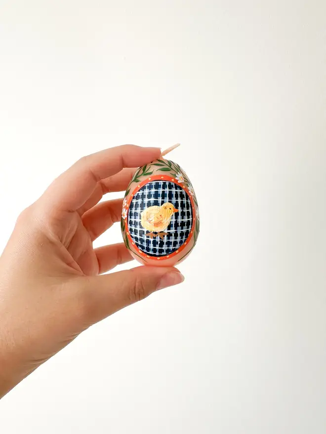 Hand Painted Easter Egg Candle Chick, a woman holding an Easter egg candle against a plain backdrop. 