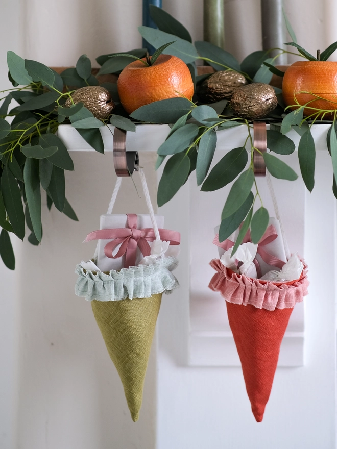 Reusable Victorian Christmas gift cones for hanging beneath festive greenery, featuring delicate ruffled trim.