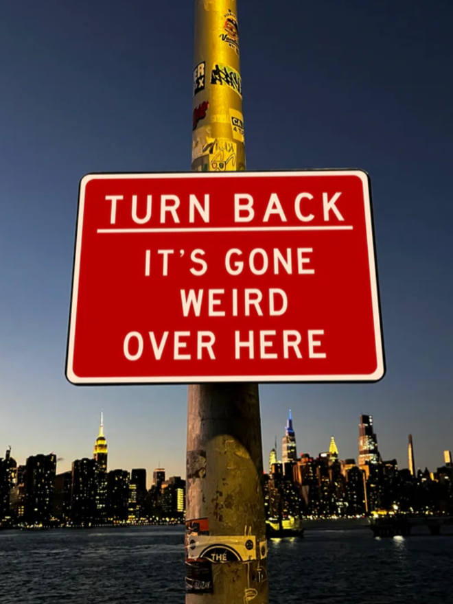 It’s Gone Weird Over Here Sign. A red sign with a plain white text-based design.