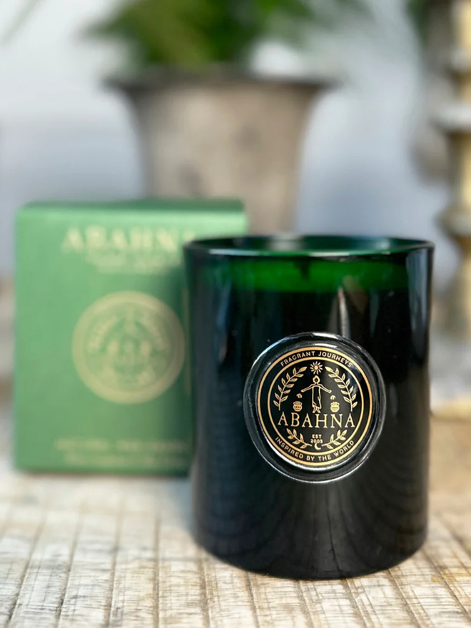 white grapefruit and may chang natural wax candle. a green glass container candle and green box.
