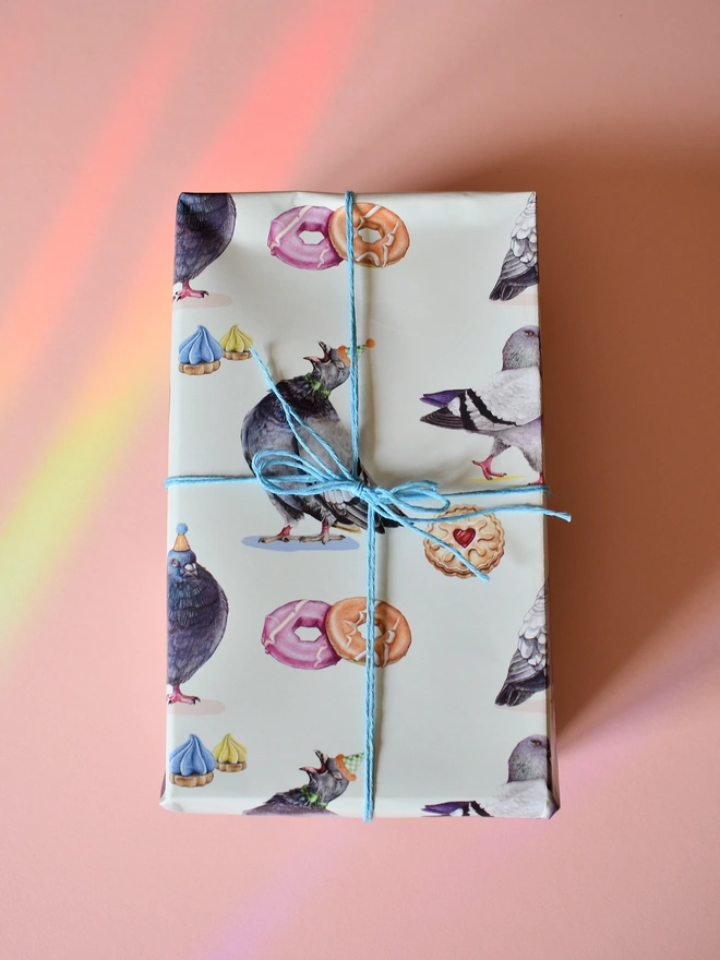 a gift wrapped in paper featuring hand illustrated pigeons and biscuits