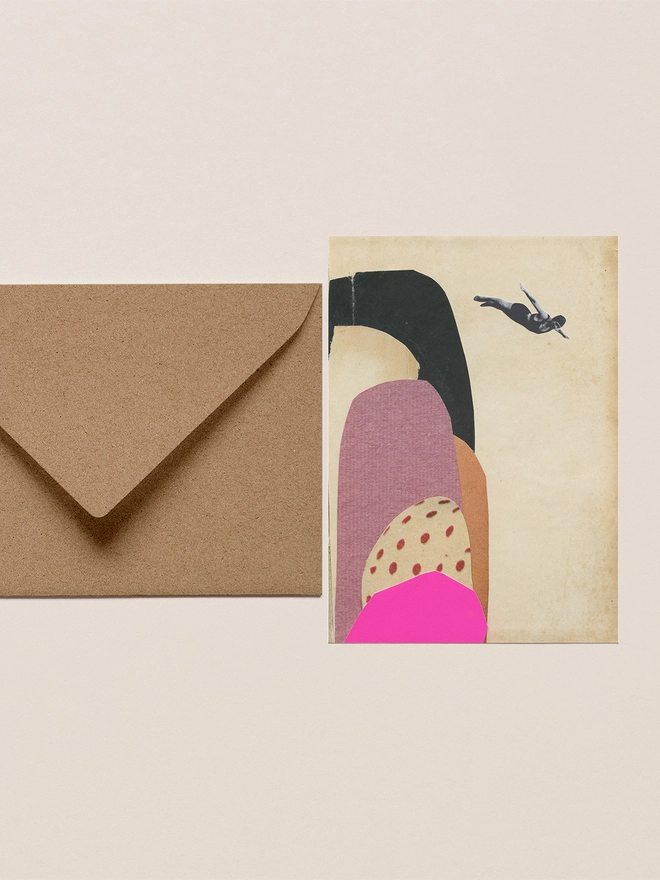 A greeting card with a brown envelope. Featuring a woman diving off colourful, large rocks into the sea.